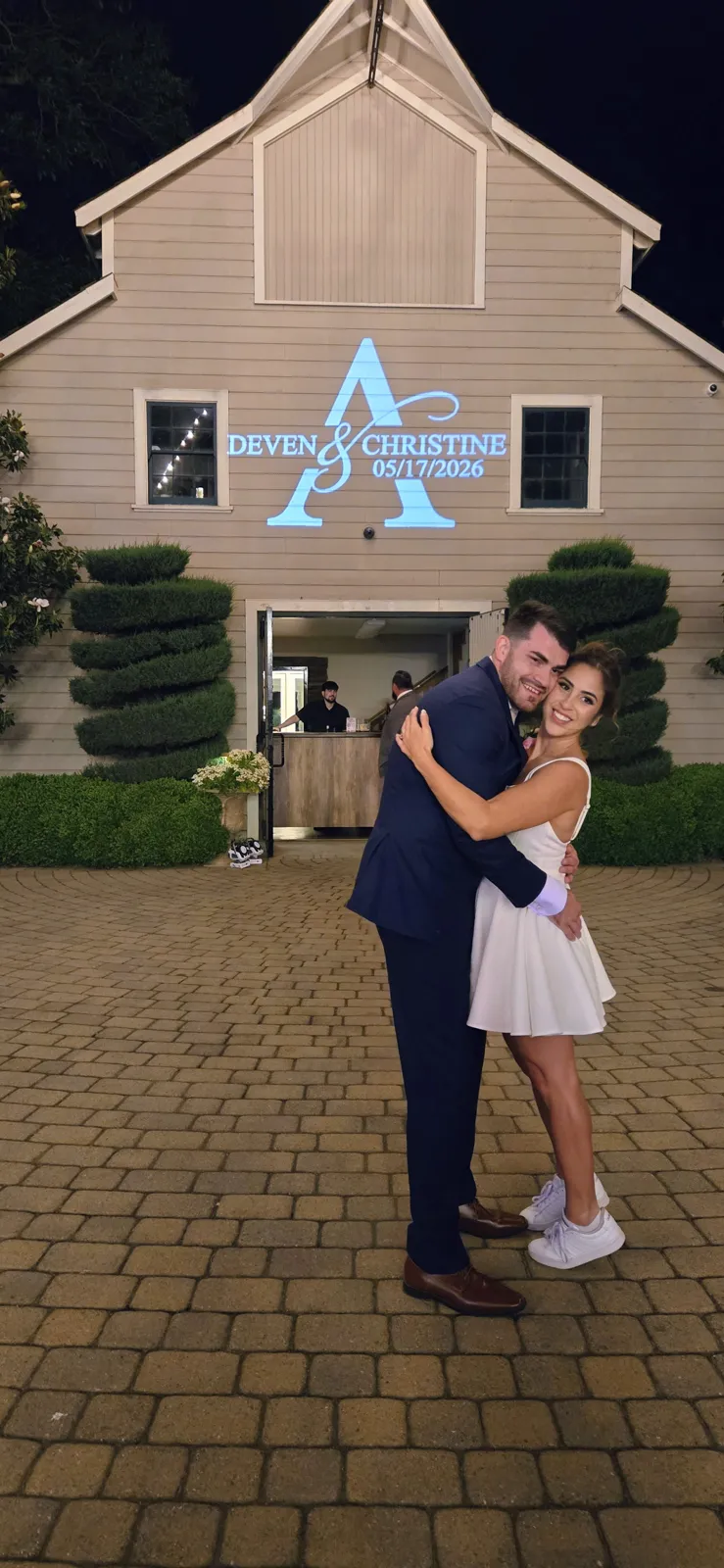 Deven and Christine with their custom monogram projected on the barn at Scribner Bend Vineyards, Sacramento wedding by J Crew Productions