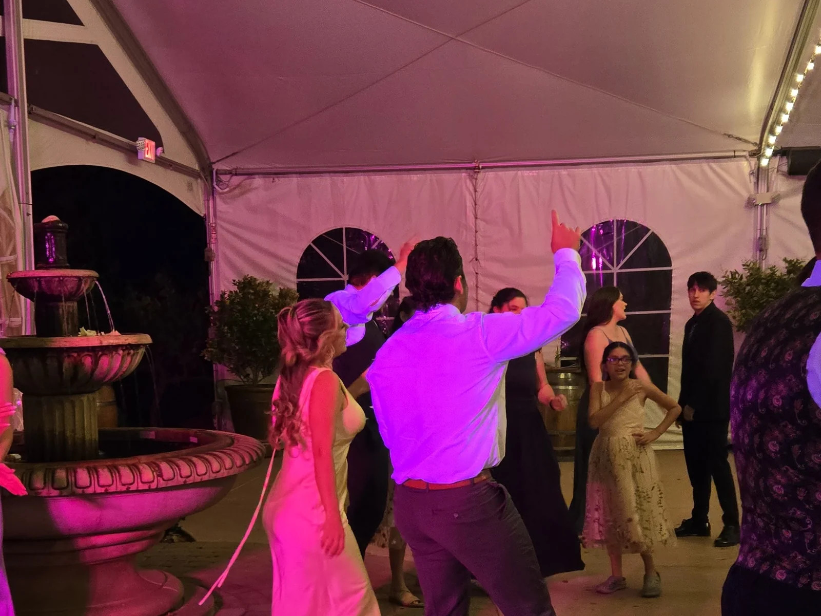 Wedding dance party with pink uplighting and gobo patterns in a tented reception