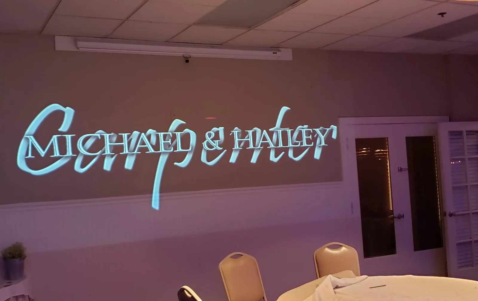 Custom monogram projection of the couple's names on the reception wall at a Sacramento wedding by J Crew Productions